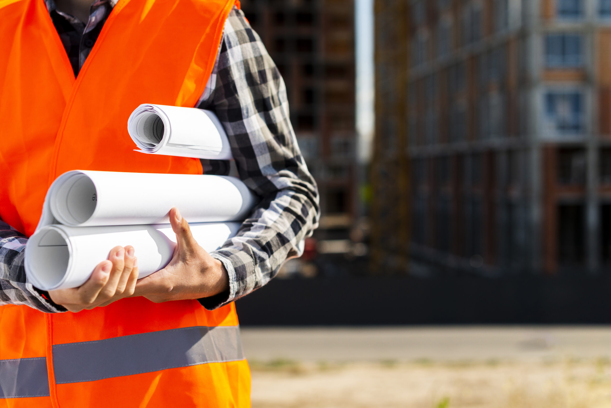 A construction worker holding layout plans