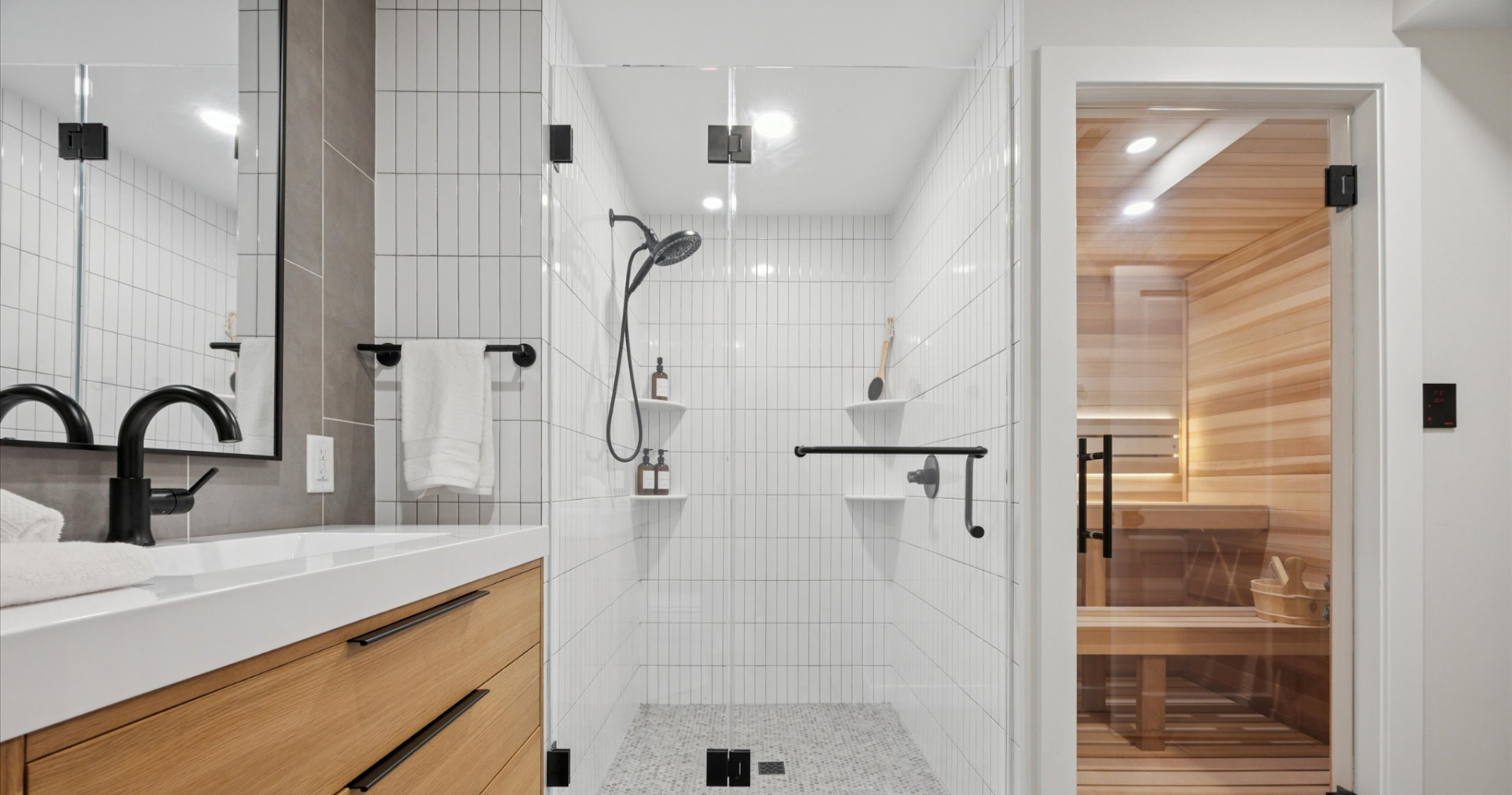 A modern bathroom remodel featuring a walk-in shower and enclosed sauna.